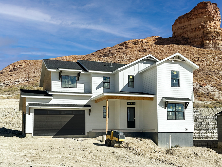 Exterior photo of charming 2-story home with 2-car garage, front porch, white siding and wood accents
